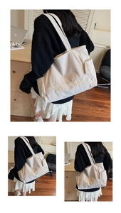 Detailed close-up of beige corduroy tote bag with embroidery and side pocket detail