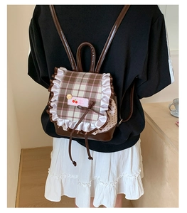 Detail eines süßen karierten Rucksack-Beutels mit weißen Rüschen und einer Schleife