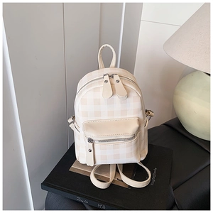 Detailansicht des beigen Karomusters und der glatten Ledertextur auf dem Mini-Rucksack