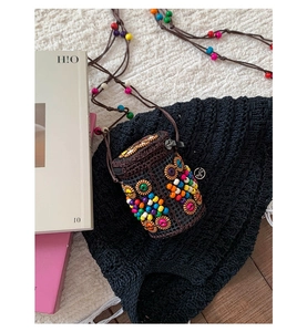 Close-up of bohemian crochet mini bag with colorful wooden beads and vibrant texture