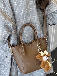 Braune Tragetasche aus Leder mit Teddybär-Anhänger und verstellbarem Schultergurt