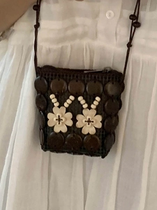 Bohemian handmade woven mini crossbody bag with floral accents and brown shoulder strap