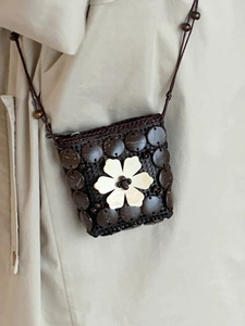 Handmade brown coconut shell woven crossbody bag with white shell flower detail