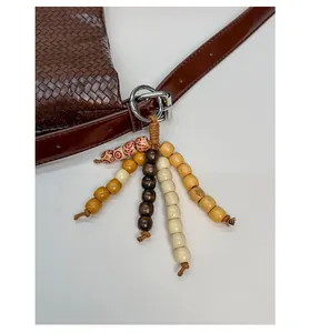 Détail du tissage en cuir avec pendentif ethnique en perles de bois colorées