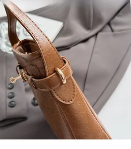 Nahaufnahme der braunen Ledertasche mit Litschi-Maserung und goldenem Metallverschluss
