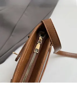 Detail des glatten goldenen Reißverschlusses und des braunen Leder-Materials der Tasche