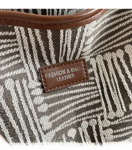 Detailed close-up of high-density textured fabric and leather logo on a tote bag