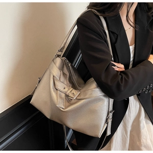 Detail of silver lychee texture leather tote with metallic buckle on fashion model