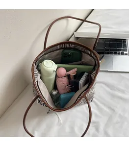 Spacious interior of a woven tote bag showing daily essentials like tablet and umbrella