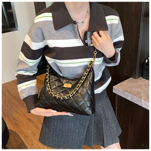 Close-up of black quilted leather hobo bag with golden chain and metallic lock detail