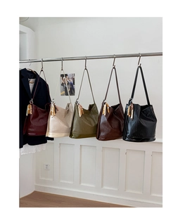 Détail de sacs seaux tissés en cinq couleurs avec des accents de perles en bois