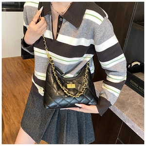 Close-up of a black quilted tote bag featuring a gold chain and turn-lock closure