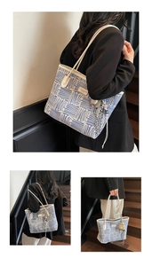 Detail of blue geometric woven tote bag featuring beaded fringe charm and cream straps