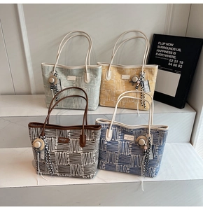 Detail showing colorful woven tote bags in green yellow brown and blue with decorative charms