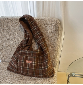 Detail of vintage brown plaid tote bag featuring a leather Stem-picking logo patch
