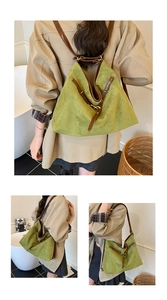Detail of green suede tote bag with brown leather straps and gold metal hardware