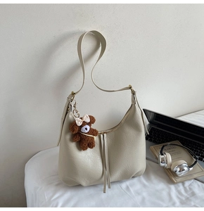 Détails du sac demi-lune crème avec fermetures éclair à pompons et charm d'ours en peluche