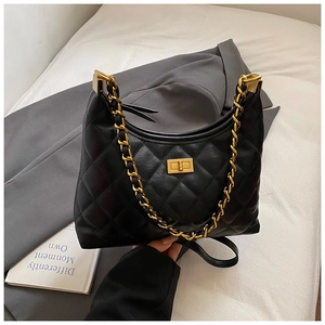 Close-up of black quilted leather hobo bag with gold chain strap and square metal buckle