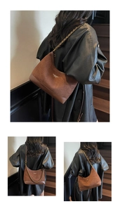 Detailed macro view of vintage brown suede shoulder bag with gold logo and metal chain