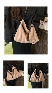 Detail view of large brown suede tote bag with black straps and golden metal hardware