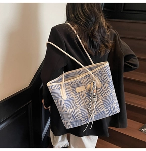 Detail of blue and white jacquard tote bag with leather trim and silk scarf accessory