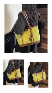 Detail of avocado green suede tote bag featuring brown leather trim and metal ring charms