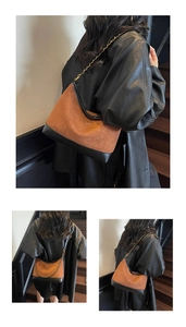 Detail of vintage patchwork shoulder bag with brown suede, black leather and gold chain