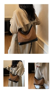 Detail of brown suede shoulder bag with black trim and elegant gold chain strap