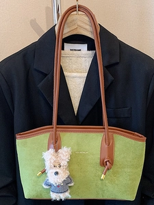 Green suede tote bag with brown leather straps and cute bear charm for daily commute