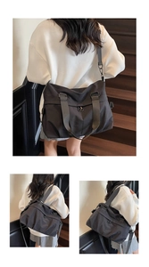 Detail of a large black nylon tote bag showing the wide adjustable shoulder strap and zippers