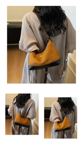 Detail view of retro yellow suede shoulder bag with gold chain and black leather trim