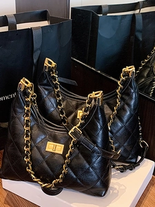 Elegant black quilted leather tote bag with gold chain strap and metallic lock closure