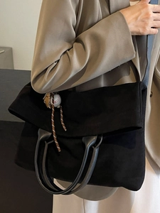 Large black matte canvas tote bag with adjustable shoulder strap and baseball pendant