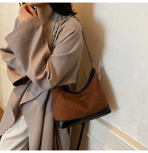 Detail of vintage suede shoulder bag with chain strap and contrast stitching design
