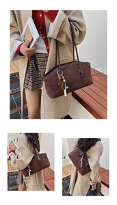 Detailansicht der braunen Wildledershoptasche mit Ledergriffen und Perlenquasten-Anhänger
