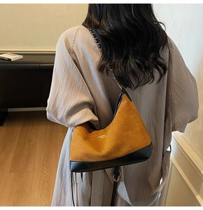 Detail view of the brown suede and black leather shoulder bag with stylish chain strap