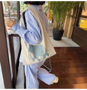 Detail of canvas tote bag featuring a vintage blue elephant print and spacious interior
