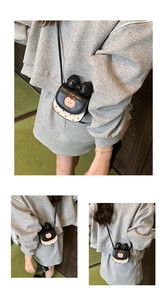 Détail d'un mini sac à bandoulière pomme avec nœud noir, broderie et motifs à pois