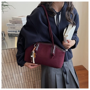 Details der burgunderroten Wildledertasche mit Ethno-Quaste und Lederbesatz