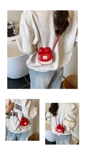 Détail du sac bandoulière rouge pomme avec nœud 3D et motifs à pois élégants
