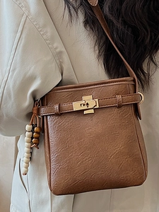 Braune Umhängetasche mit Litschi-Struktur, Goldverschluss und Perlenanhänger-Accessoire
