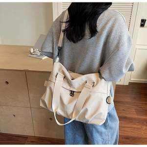 Detailed view of cream large canvas tote bag showing dual straps and metal adjustment buckle