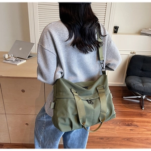 Detail view of olive green large capacity crossbody bag with durable nylon and wide straps