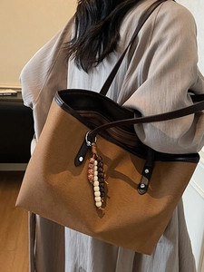 Brown canvas tote bag with leather straps and vintage beaded charm pendant
