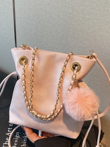 Pink PU leather drawstring bucket bag with gold chain strap and fuzzy pompom charm