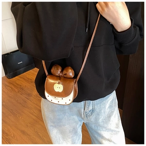 Détail du mini sac à bandoulière pomme avec nœud décoratif et motif à pois chic