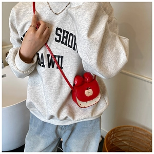 Détail du mini sac bandoulière en forme de pomme avec nœud rouge et motifs à pois