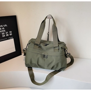 Detail view of military green nylon tote bag featuring dual front zipper compartments