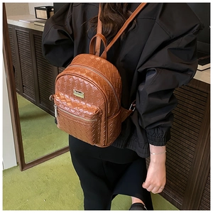 Sac à dos marron en cuir tressé porté sur le dos pour montrer la taille réelle