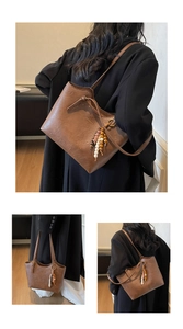 Detailed close-up of brown vintage tote bag featuring a colorful wooden bead tassel charm